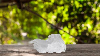 Kristal berrak alum küpleri ya da kahverengi tahta üzerinde potasyum alum. Kimyasal bileşik madde. Güzellik, kaplıca ve koltuk altı tedavi kavramı endüstriyel. 