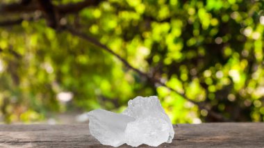 Kristal berrak alum küpleri ya da kahverengi tahta üzerinde potasyum alum. Kimyasal bileşik madde. Güzellik, kaplıca ve koltuk altı tedavi kavramı endüstriyel. 