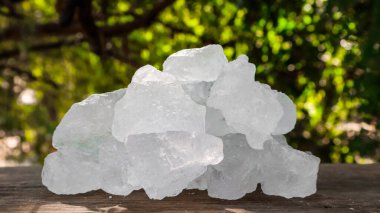 Kristal berrak alum küpleri ya da kahverengi tahta üzerinde potasyum alum. Kimyasal bileşik madde. Güzellik, kaplıca ve koltuk altı tedavi kavramı endüstriyel. 