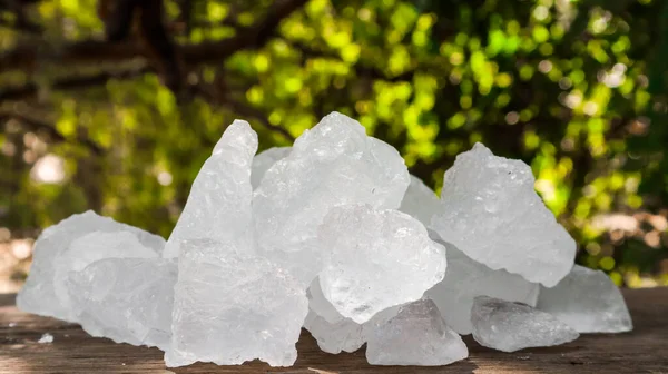 Kristal berrak alum küpleri ya da kahverengi tahta üzerinde potasyum alum. Kimyasal bileşik madde. Güzellik, kaplıca ve koltuk altı tedavi kavramı endüstriyel. 