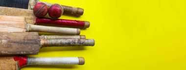 Brown wooden cricket handles which are bound by cotton yarn and artificial leather on yellow background
