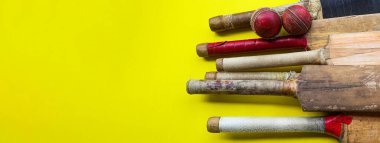 Brown wooden cricket handles which are bound by cotton yarn and artificial leather on yellow background
