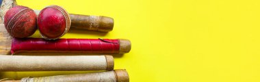 Brown wooden cricket handles which are bound by cotton yarn and artificial leather on yellow background