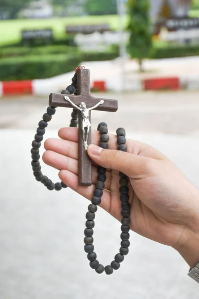 Brown wooden cross holding in hand soft and selective focus on the cross