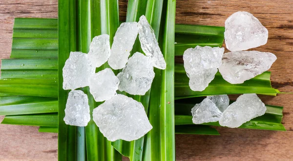 Crystal clear alum cubes or Potassium alum on green leaf. Chemical compound substance. Concept for beauty , spa and underarm treatment industrial.