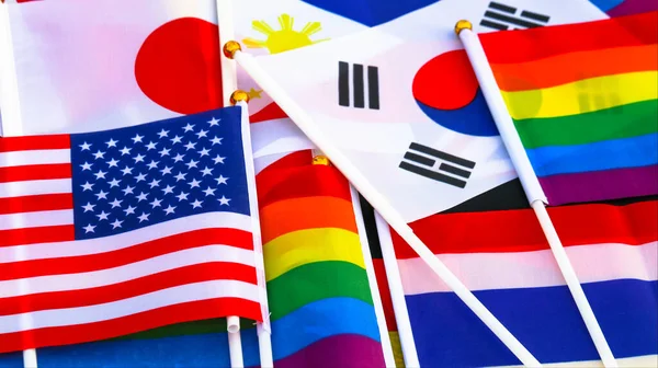 LGBT rainbow flag stay together with the flag of countries background to enhance LGBTQ+ community around the world