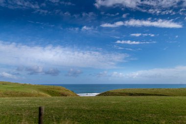 Sahil şeridi boyunca çiftçi tarlaları ve kıyı manzaraları var. Yeni Plymouth, Yeni Zelanda