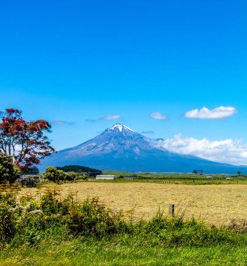 Taranaki Dağı kırsal alanda araba sürerken gökyüzüne doğru yükselir. Taranaki, Yeni Zelanda