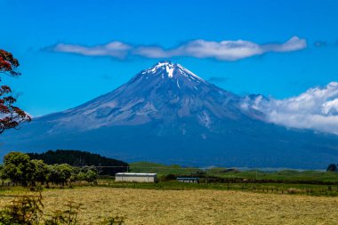 Taranaki Dağı kırsal alanda araba sürerken gökyüzüne doğru yükselir. Taranaki, Yeni Zelanda