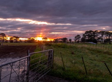 Kırsal kesimde renkli güneş batıyor. Taranaki, Yeni Zelanda