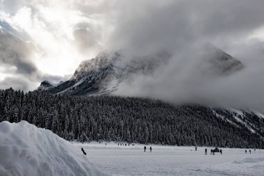 Arı kovanı ve şeytan başparmağı bulutlu buz patencilerine göz kulak olur. Louise Gölü. Banff Ulusal Parkı, Alberta, Kanada