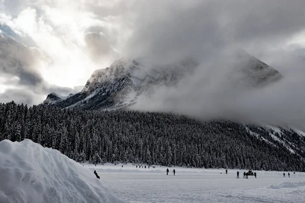Arı kovanı ve şeytan başparmağı bulutlu buz patencilerine göz kulak olur. Louise Gölü. Banff Ulusal Parkı, Alberta, Kanada