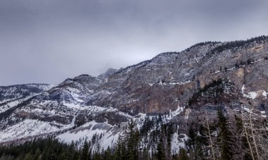 Yol boyunca kar altında ağır bulutlar var. Yoho Ulusal Parkı, İngiliz Kolombiyası, Kanada