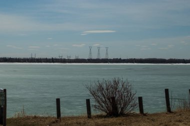 Buz hala bir bahar günü erken saatlerde gölün tepesine tutunur. Glkeniffer Gölü PRA, Red Deer County, Alberta, Kanada