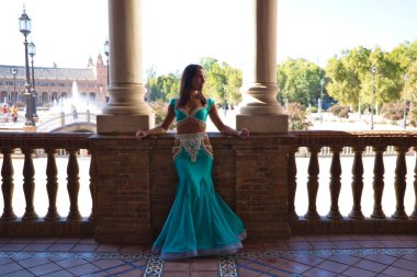 Genç ve güzel dansçı bir fotoğraf çekiminde kameraya poz veriyor. Kadın çok güzel ve geleneksel kıyafetler giyiyor. Güzellik, folklor ve göbek dansı konsepti.