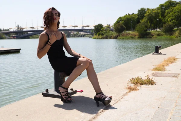 Genç Latin Transseksüel Kadın Nehir Rıhtımında Oturan Siyah Elbiseli Farklılık — Stok fotoğraf