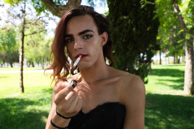 Genç Latin ve transseksüel kadın güzel siyah iç çamaşırı giymişler. Kadın kameraya poz veriyor ve sigara içiyor. Farklılık, transseksüel ve homoseksüel ifade özgürlüğü kavramları.