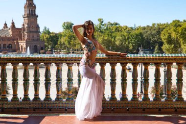 Genç ve güzel dansçı bir fotoğraf çekiminde kameraya poz veriyor. Kadın çok güzel ve geleneksel kıyafetler giyiyor. Güzellik, folklor ve göbek dansı konsepti.