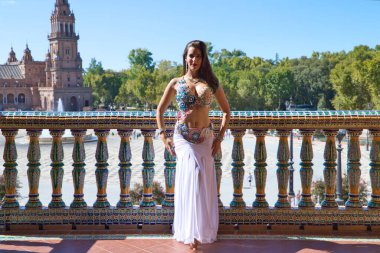 Genç ve güzel dansçı bir fotoğraf çekiminde kameraya poz veriyor. Kadın çok güzel ve geleneksel kıyafetler giyiyor. Güzellik, folklor ve göbek dansı konsepti.