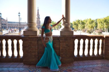 Genç ve güzel dansçı bir fotoğraf çekiminde kameraya poz veriyor. Kadın çok güzel ve geleneksel kıyafetler giyiyor. Güzellik, folklor ve göbek dansı konsepti.