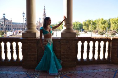 Genç ve güzel dansçı bir fotoğraf çekiminde kameraya poz veriyor. Kadın çok güzel ve geleneksel kıyafetler giyiyor. Güzellik, folklor ve göbek dansı konsepti.