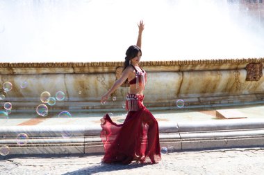 Meydanda dans eden genç ve güzel bir dansçı. O, elinde beyaz bir peçeyle açık mavi giyinmiş. Afrika ve Asya 'dan gelen dünya folklor kavramı.