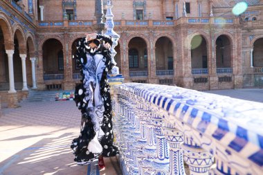 İspanyol, güzel, esmer flamenko dansçısı tipik siyah benekli flamenko elbisesi var. O, Sevilla 'daki parkta dans ediyor. Flamenko kavramı insanlığın kültürel mirası.