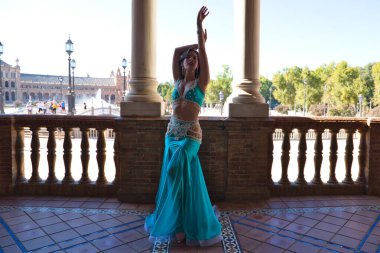 Genç ve güzel dansçı bir fotoğraf çekiminde kameraya poz veriyor. Kadın çok güzel ve geleneksel kıyafetler giyiyor. Güzellik, folklor ve göbek dansı konsepti.