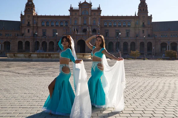İki genç ve güzel dansçı çeşmenin önünde bir meydanda dans ediyorlar. Açık mavi giyinmişler ve ellerinde beyaz peçeler var. Afrika ve Asya 'dan gelen dünya folklor kavramı.