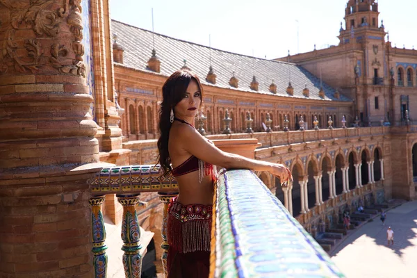 Güzel, yetişkin bir dansçı meydanda bir balkona yaslanmış dalgın ve üzgün görünüyor. Dans konsepti ve yüz ifadeleri.