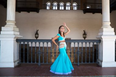 Genç ve güzel dansçı bir fotoğraf çekiminde kameraya poz veriyor. Kadın çok güzel ve geleneksel kıyafetler giyiyor. Güzellik, folklor ve göbek dansı konsepti.