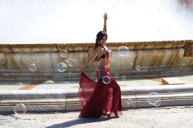 Meydanda dans eden genç ve güzel bir dansçı. O, elinde beyaz bir peçeyle açık mavi giyinmiş. Afrika ve Asya 'dan gelen dünya folklor kavramı.