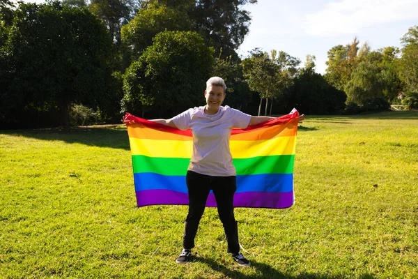 gender non-binary person is with the gay pride flag on his body on his sword. He is looking at the camera. Concept of non-binary and androgynous. Diversity and gay pride.