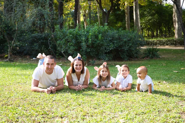 Portrait Parents Heureux Avec Leurs Trois Enfants Couchés Dans Parc — Photo