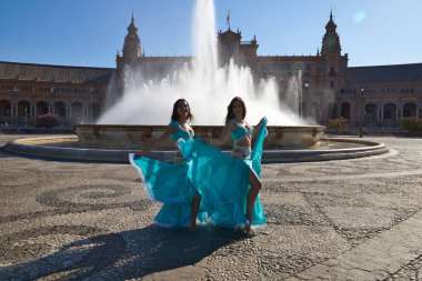İki genç ve güzel dansçı çeşmenin önünde bir meydanda dans ediyorlar. Açık mavi giyinmişler ve ellerinde beyaz peçeler var. Afrika ve Asya 'dan gelen dünya folklor kavramı.