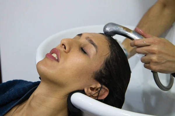 Uzman kuaför tarafından kuaförde saçı yıkanmış transseksüel bir kadın. Güzeller güzeli müşterimiz kuaförde masaj yaparken kendini rahat hissediyor..