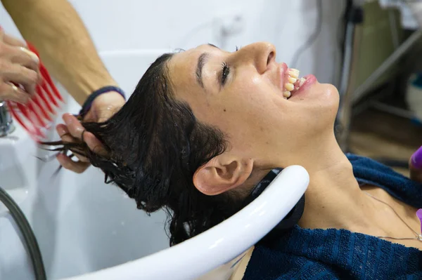 美容室でプロの美容師に頭の毛を洗われて横になっているトランスジェンダーの女性 美容室ヘアサロンの美容師マッサージヘッドとしてリラックスした美しいクライアント感 — ストック写真