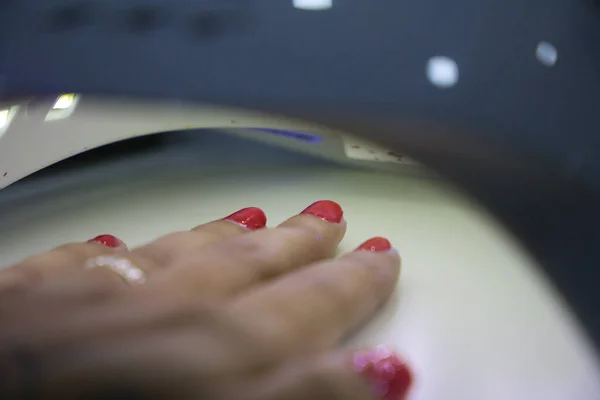 Kvinnans Hand Torkar Sina Nypolerade Naglar Ultraviolett Lampa Nagelsalong Skönhetssalong — Stockfoto