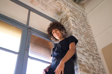 Güzel bir kadın stüdyosunun vitrininde geziyor. Kadınlar kameraya bakıp eğlenirken farklı jestler yaparlar. Stüdyoda çok fazla doğal ışık var. İfadeleri ve ruh hallerini kavra.