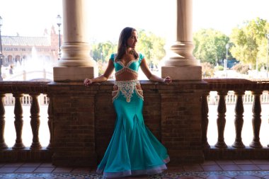 Genç ve güzel dansçı bir fotoğraf çekiminde kameraya poz veriyor. Kadın çok güzel ve geleneksel kıyafetler giyiyor. Güzellik, folklor ve göbek dansı konsepti.