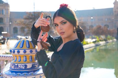 Siyah çingene kostümüyle flamenko dansı yapan bir kadının portresi. Sarı benekli, saçlarında kırmızı çiçek ve ellerinde kastanyetlerle. İnsanlığın Flamenko kültürel mirası kavramı.