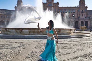 Meydanda dans eden genç ve güzel bir dansçı. O, elinde beyaz bir peçeyle açık mavi giyinmiş. Afrika ve Asya 'dan gelen dünya folklor kavramı.