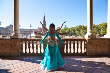 Açık mavi giyinmiş üç güzel dansçı şehir meydanında dans ediyor. Göbek dansı ve göbek dansı konsepti, Afrika folkloru..