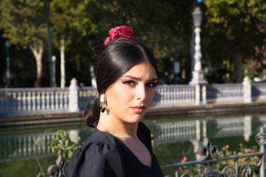 Flamenko dansçısı, esmer ve güzel, tipik siyah kostümlü, sarı benekli bir kadın parkta bir bankta oturuyor. İnsanlığın kültürel mirası Flamenko kavramı.