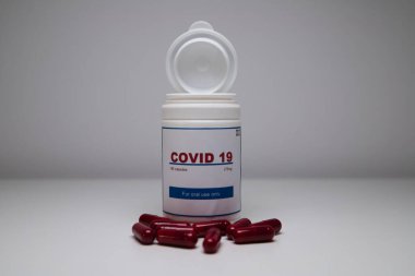 Beyaz bir şişe covid-19 antiviral hap açıldı ve laboratuvar tezgahındaki şişedeki haplarla birlikte. Yeni antiretroviral tedavi hapı Covid-19.
