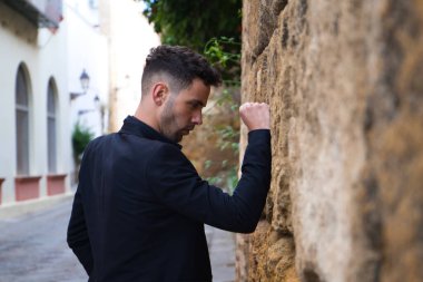 Çingene adam flamenko yapıyor, genç ve yakışıklı, siyah giyinmiş, yumruğuyla duvara yaslanıyor. İnsanlığın Flamenko kültürel mirası.