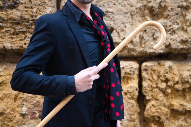 Çingene adam flamenko yapıyor, siyah ve kırmızı ayakkabılar giymiş genç ve yakışıklı ve tahta bir baston taştan bir duvarın arkasında poz veriyor. İnsanlığın Flamenko kültürel mirası.