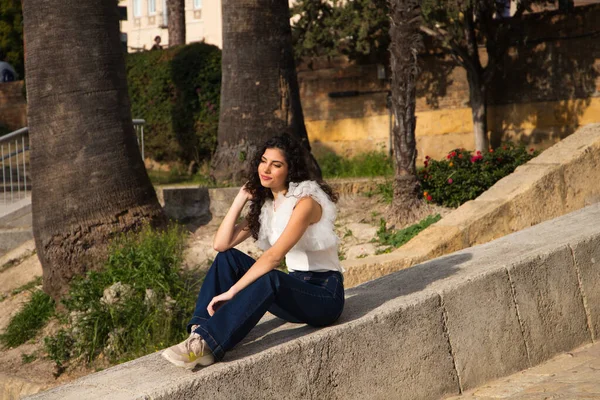 Parktaki Taş Bir Duvarda Oturan Güzel Genç Bir Kadın Düşünceli — Stok fotoğraf