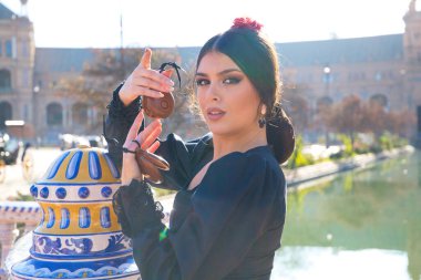 Siyah çingene kostümüyle flamenko dansı yapan bir kadının portresi. Sarı benekli, saçlarında kırmızı çiçek ve ellerinde kastanyetlerle. İnsanlığın Flamenko kültürel mirası kavramı.