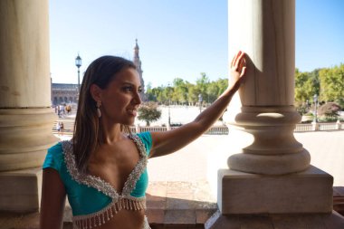 Genç ve güzel dansçı bir fotoğraf çekiminde kameraya poz veriyor. Kadın çok güzel ve geleneksel kıyafetler giyiyor. Güzellik, folklor ve göbek dansı konsepti.